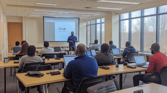 Google Cloud promove treinamento em uma sala moderna, com alunos focados em suas telas de laptop, enquanto um instrutor apresenta conteúdo em destaque. O ambiente bem iluminado e organizado oferece uma experiência de aprendizado eficiente e imersiva.