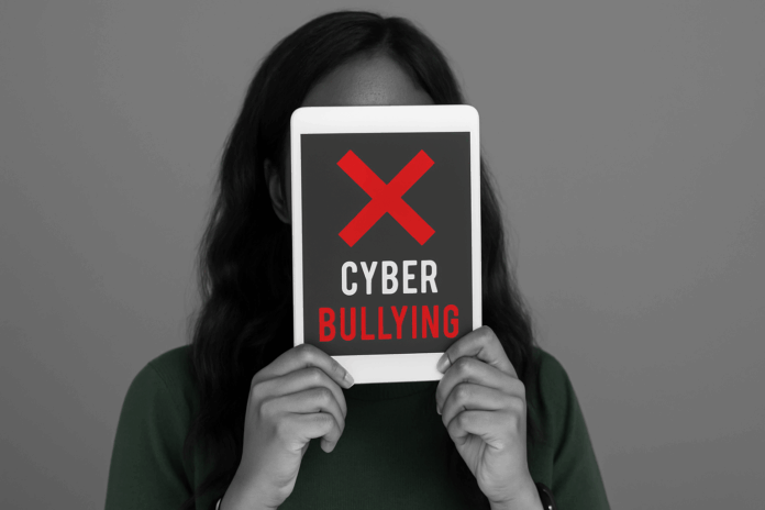 Mulher segurando tablet com mensagem contra o cyberbullying.