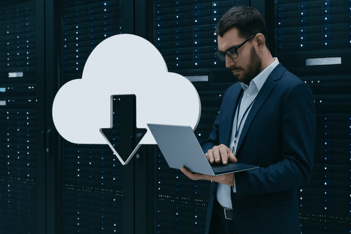 Repatriação de dados corporativos representada por um profissional de TI em data center usando laptop ao lado de ícone de nuvem com seta para baixo.