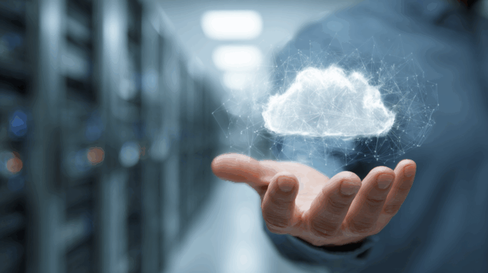 Mão segurando nuvem digital representando integração entre data center e computação em nuvem em ambientes híbridos de TI